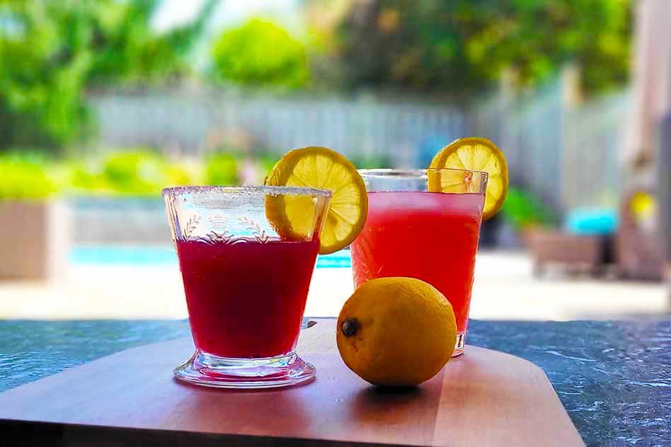 Blackberry Limoncello Martini and Lemonade on a cutting board with a lemon.