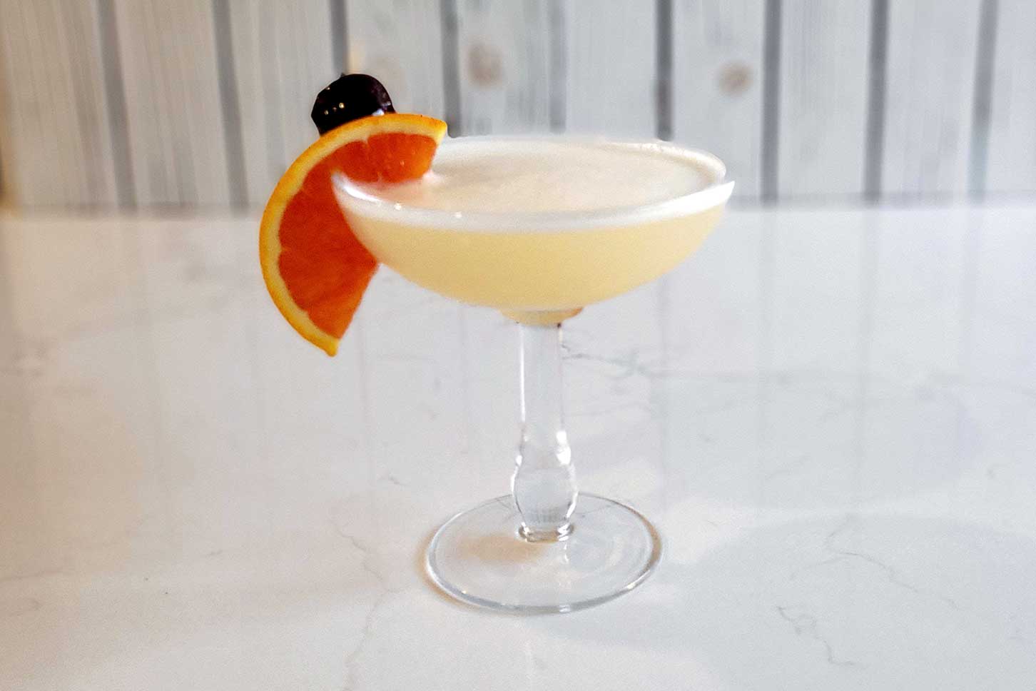 The classic whiskey sour with an orange slice and cherry garnish.