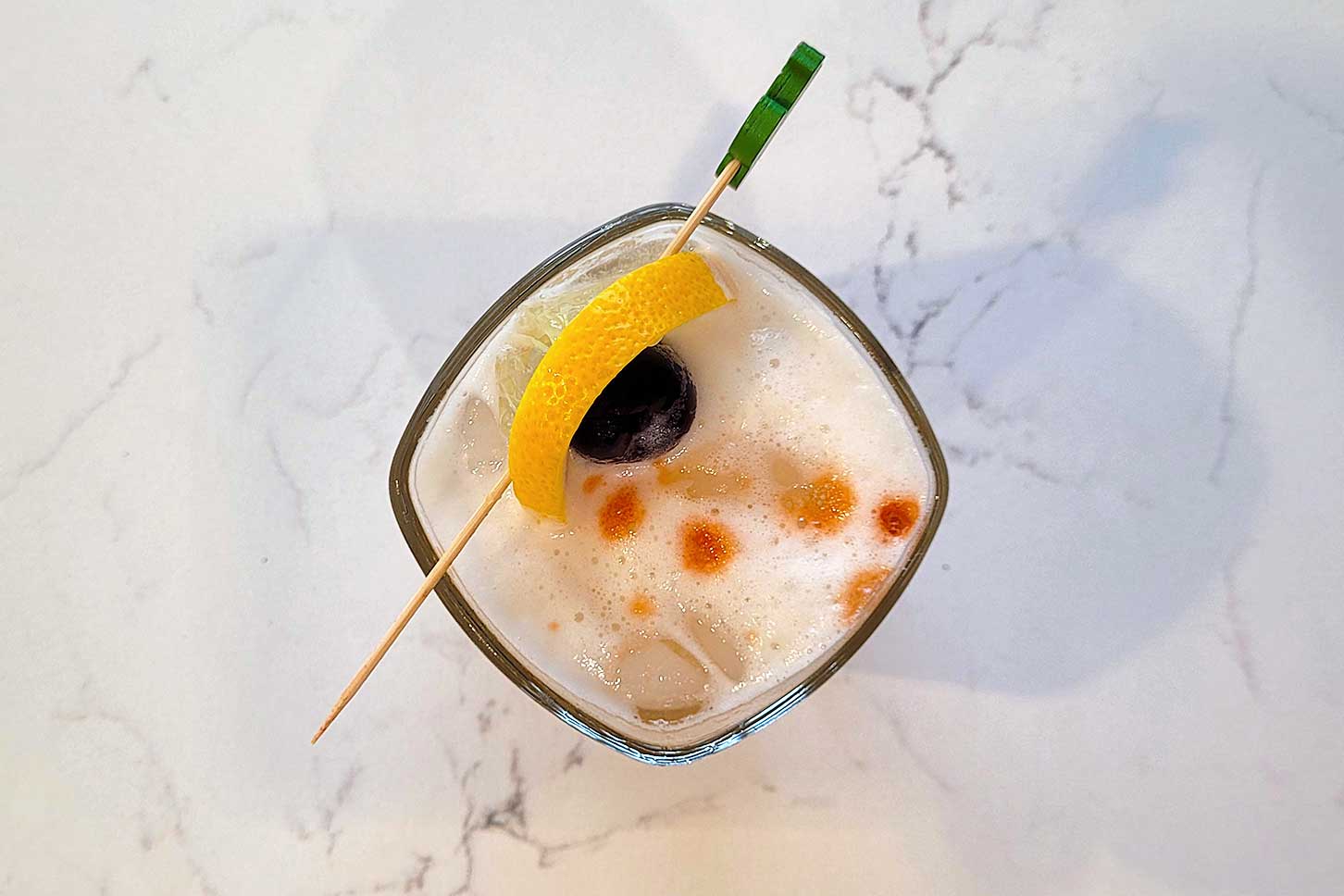 The Amaretto Sour with a lemon and bourbon cherry garnish.