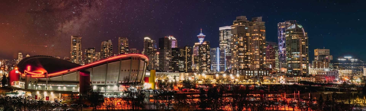 Calgary skyline at night with the Saddledome and the Milky Way.