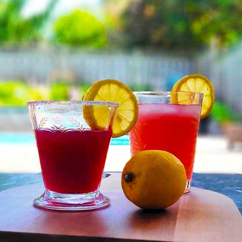 Blackberry Limoncello Martini and Lemonade on a cutting board with a lemon.