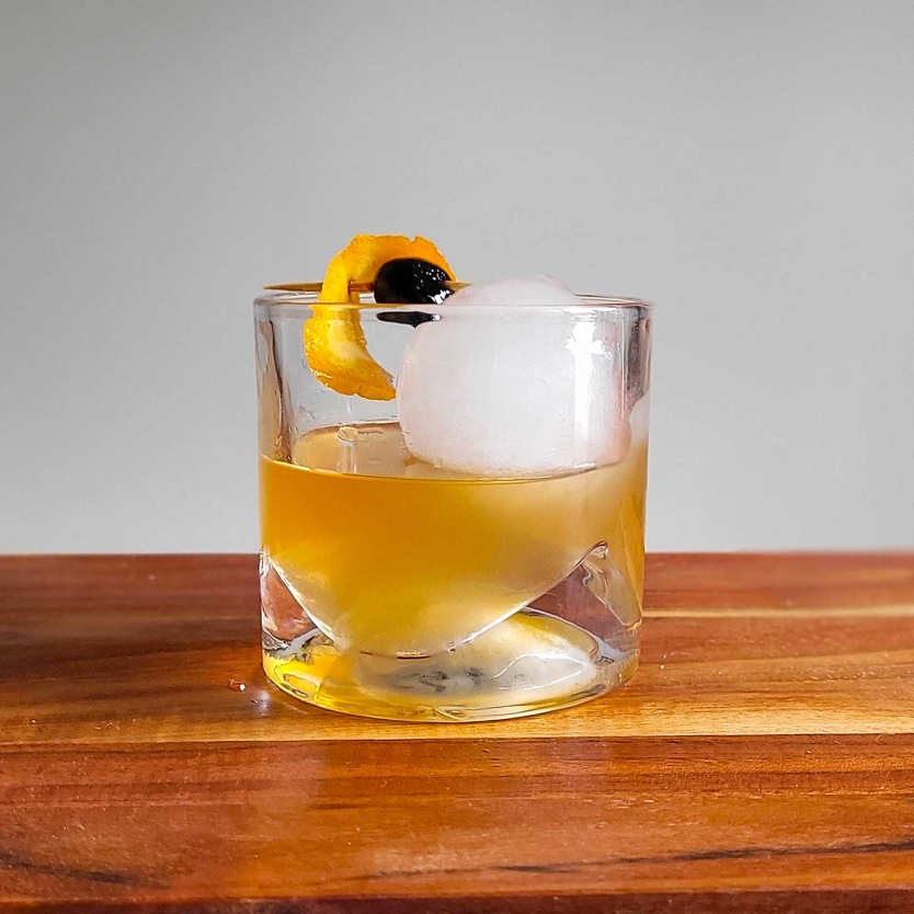 Brown Butter Old Fashioned with a maraschino cherry and a twist.