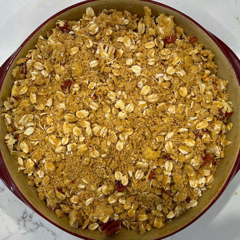 Baked peach bourbon crisp on a counter.