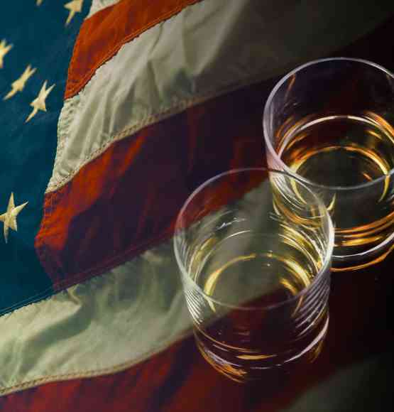 Two glasses of whiskey with an American flag.
