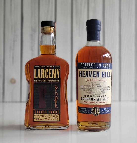 Bottles of Heaven Hill Bottled-in-Bond and Larceny Barrel Proof Whiskey on a counter.