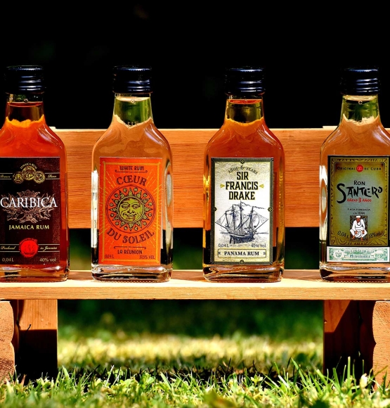 4 bottles of rum on a miniature park bench.