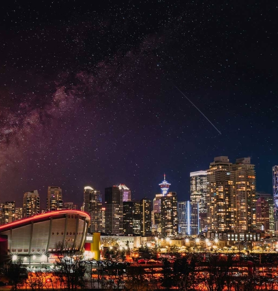 Calgary skyline at night with the Saddledome and the Milky Way.