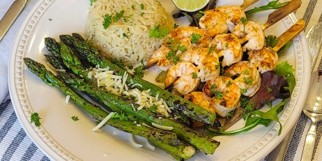 BBQ Tequila Lime Shrimp on a bed of greens with rice and asparagus.