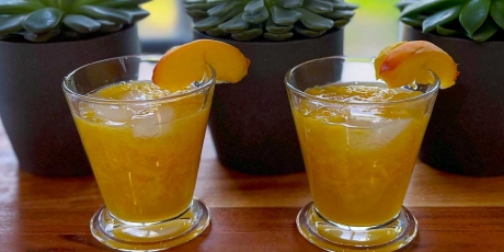 Two Rustic Peach Martinis on a cutting board.
