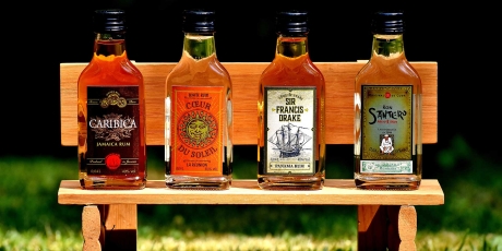 4 bottles of rum on a miniature park bench.