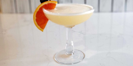 The classic whiskey sour with an orange slice and cherry garnish.
