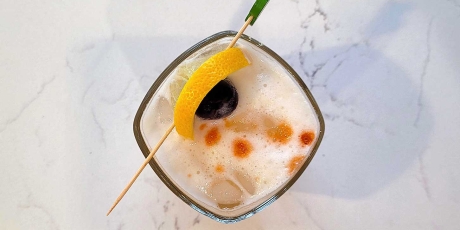 The Amaretto Sour with a lemon and bourbon cherry garnish.