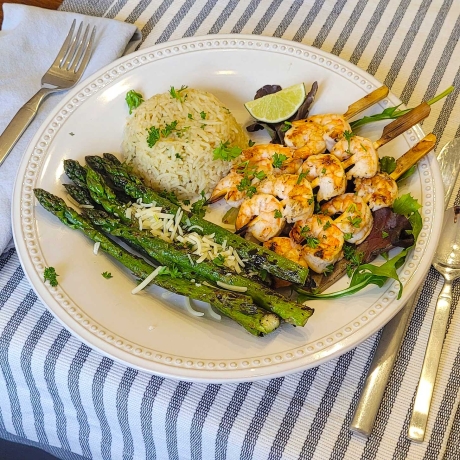 BBQ Tequila Lime Shrimp on a bed of greens with rice and asparagus.