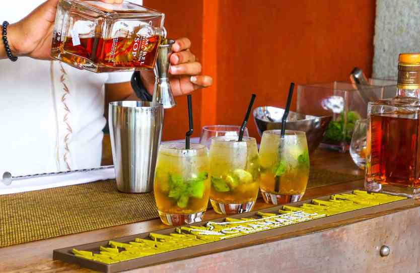Bartender making rum cocktails on a bar.